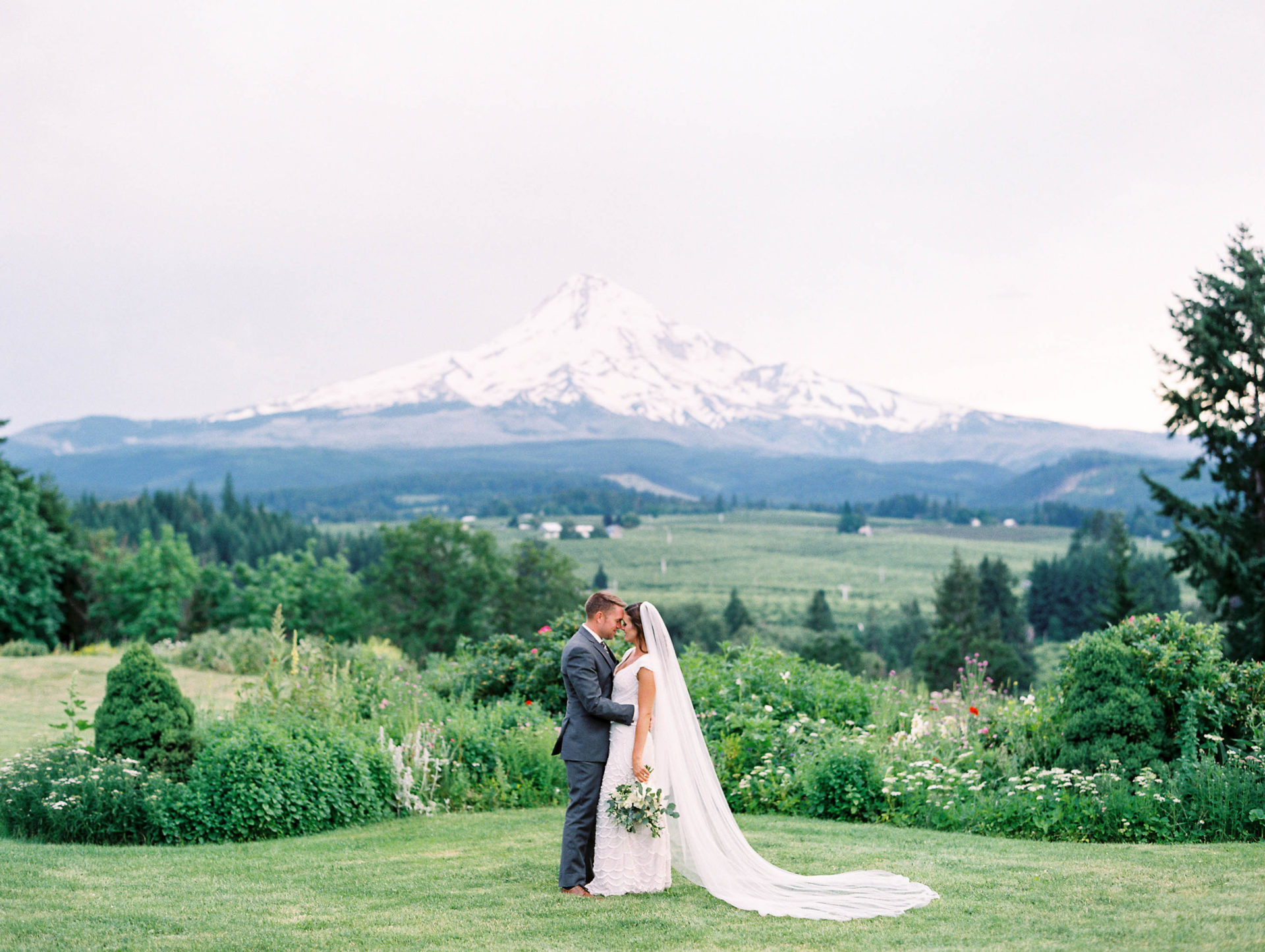 Bride and groom posing on grass at Mt. Hood Organic Farms